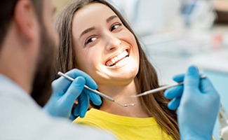 Implant dentist in Ocala helping a smiling patient