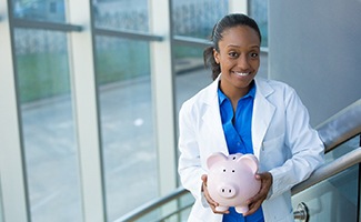 Dentist holding a piggy bank