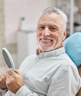 Woman with dental implants in Ocala smiling at an apple