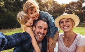 family of four smiling outdoors