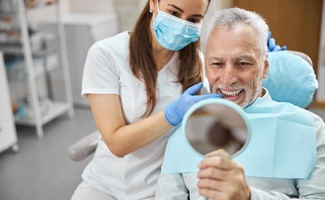 Man admiring his new dental bridge in Ocala