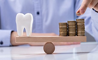 Model of a tooth and stacks of coins on a seesaw