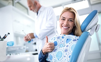 A woman giving a thumbs up after seeing her dentist in Ocala