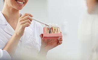 A dentist pointing to a dental implant in Ocala to show a patient