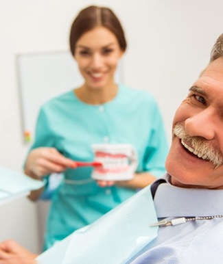 a patient smiling after receiving his implant dentures