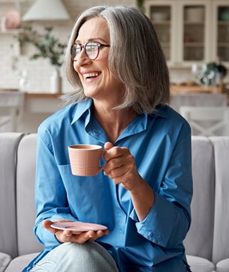 a woman smiling comfortably after receiving implant dentures