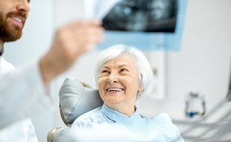 Older woman smiling during her implant consultation