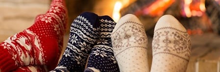 feet with socks on, by a fireplace