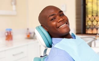 person sitting in dentist’s chair smiling