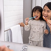 A woman and little girl brushing their teeth at home in Ocala