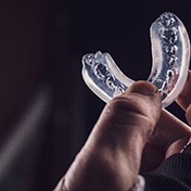An up-close image of a person holding a customized mouthguard in Ocala
