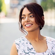 A young woman wearing a floral blouse and smiling in Ocala