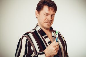 surprised man looking at toothbrush