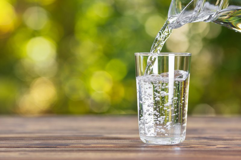 a pitcher of water being poured into a glass