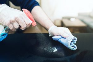 person sanitizing the surfaces in a dental office