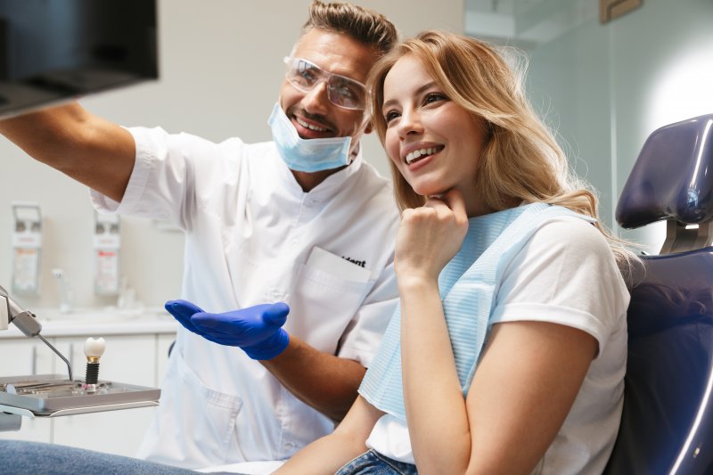 Dentist and patient smiling while looking at X-ray