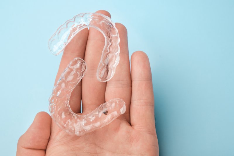 person holding clear aligners