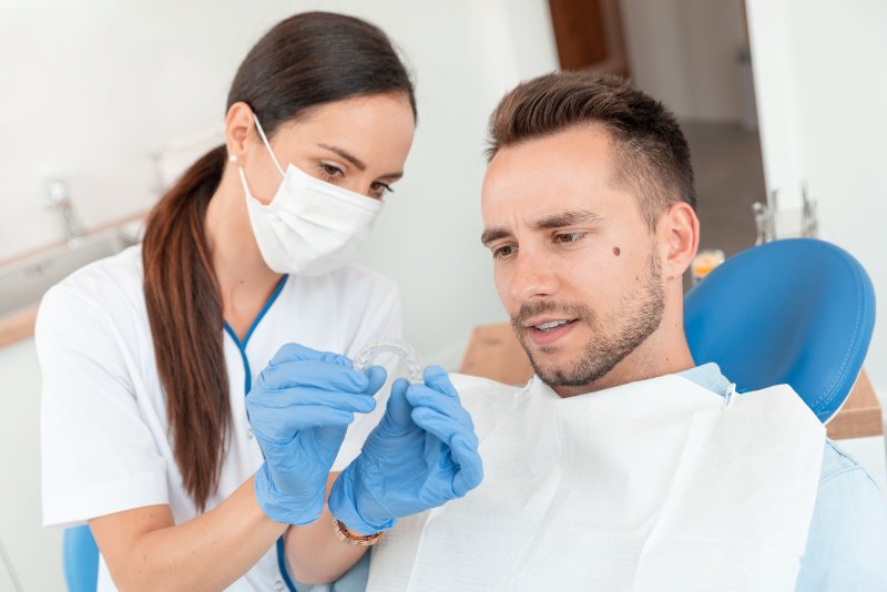 Dentist showing patient how to prepare for Invisalign braces