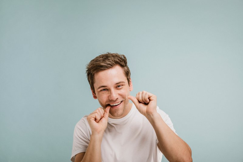 man flossing with Invisalign in Ocala