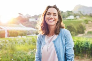 person smiling while taking a hike outdoors