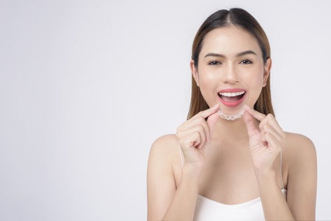 woman inserting clear aligners