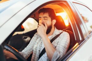 Man tired while driving in the morning