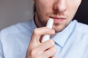 Man applying chapstick. 