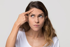 Woman with wrinkles on forehead thinking about BOTOX® 
